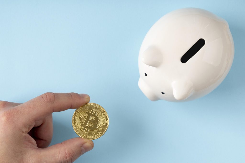 Top View Piggy Bank With Person Holding Bitcoin 1024x683