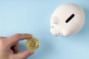 Top View Piggy Bank With Person Holding Bitcoin 300x200